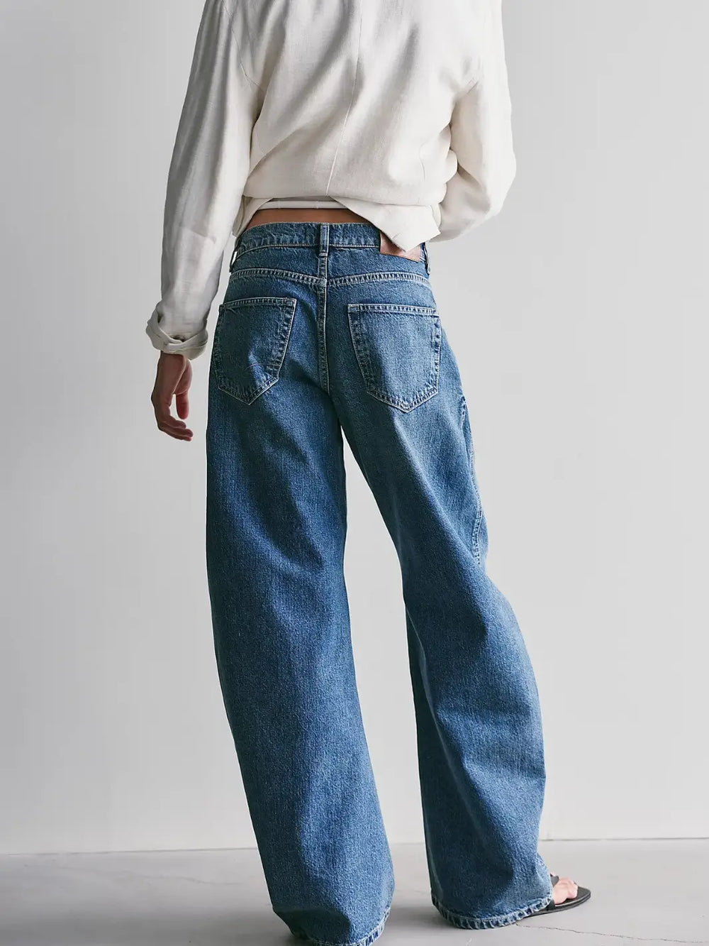 Back view showing the loose leg silhouette and back pockets of the Free People We the Free Golden Hour Trouser Jeans in Deacon Blue | Twentyseven