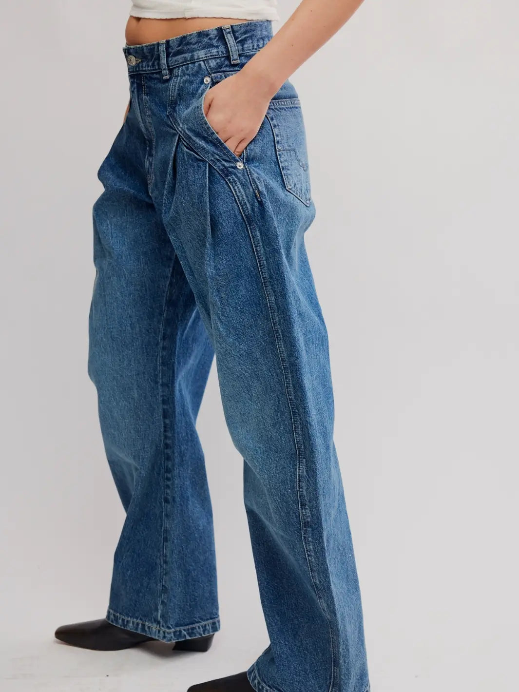 Side three-quarter view showing the pleated pocket detailing on the Free People We the Free Golden Hour Trouser Jeans in Deacon Blue | Twentyseven