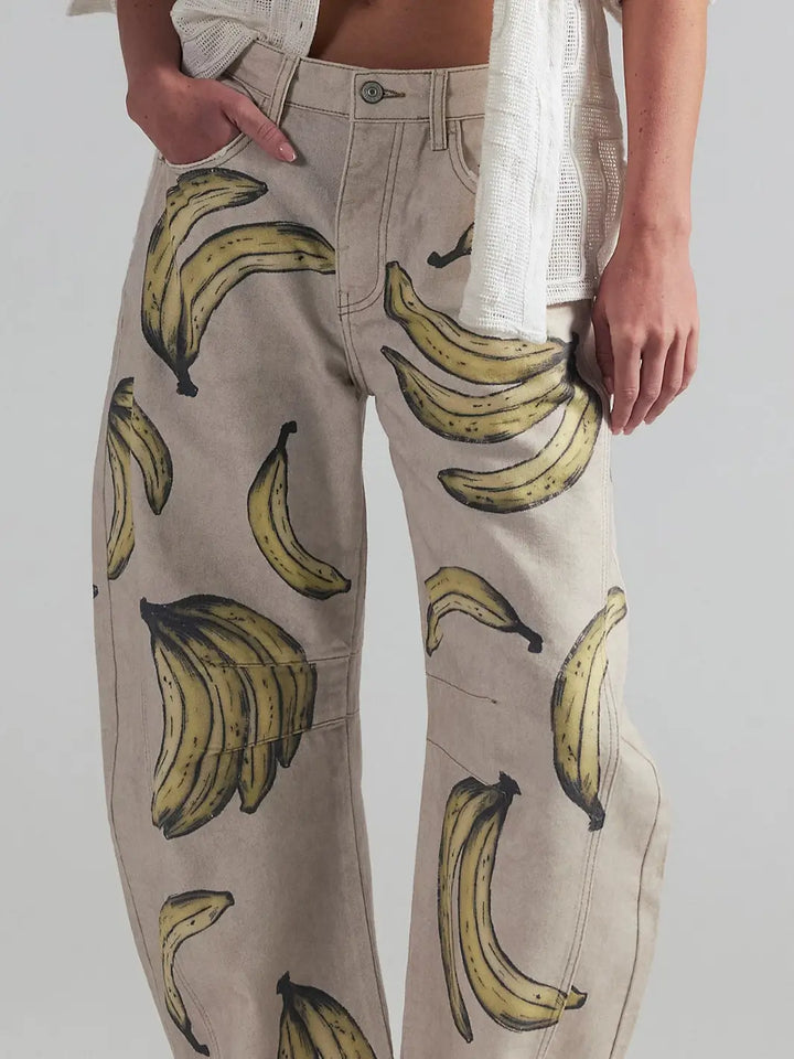 A close-up shot focusing on a model wearing the Free People Good Luck Printed Barrel Jeans in Go Bananas, showing the detailed banana graphic print on the front | Twentyseven Toronto
