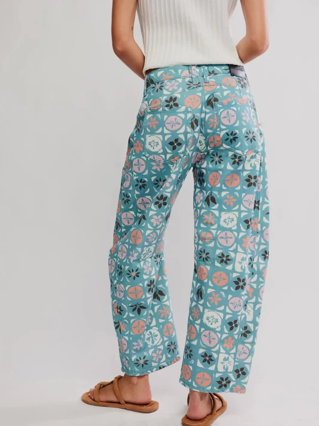 A low-angle rear view shows the back paneling, classic leather brand patch, and relaxed seating design of the Free People Good Luck Printed Barrel Jeans in Jade Combo Ditsy Block | Twentyseven Toronto