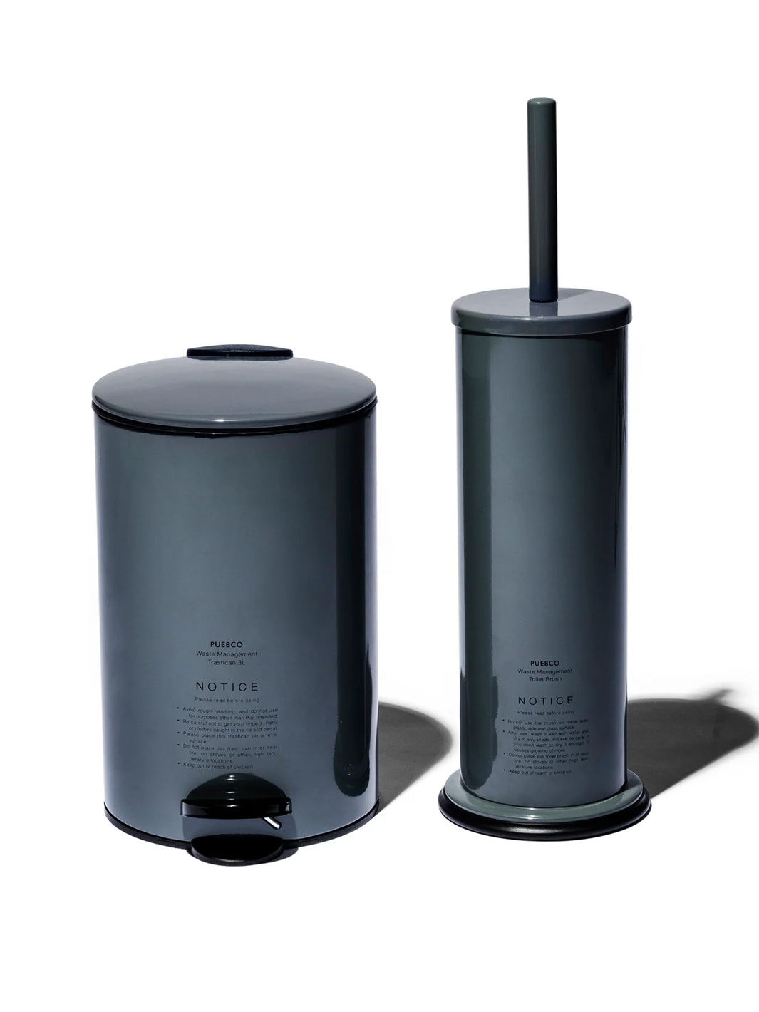 Puebco Grey Toilet Brush with cylindrical steel holder displayed beside the matching Grey Trash Can with foot pedal, against a white background | Twentyseven Toronto