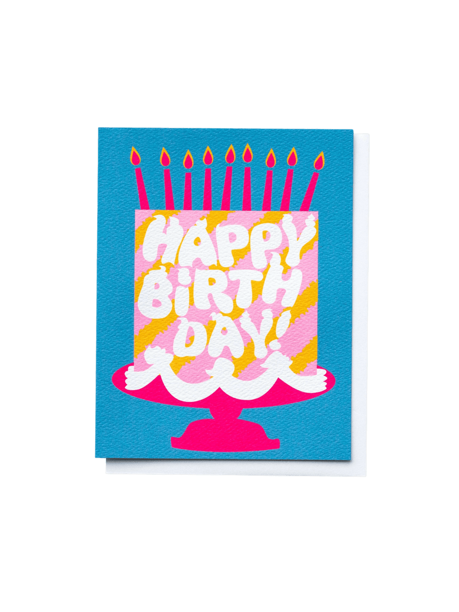 The Banquet Workshop Happy Birthday Pink Cake Dreams Note Card features a bold illustration of a pink and yellow striped birthday cake on a hot pink stand, complete with nine burning candles, set against a vibrant blue background | Twentyseven