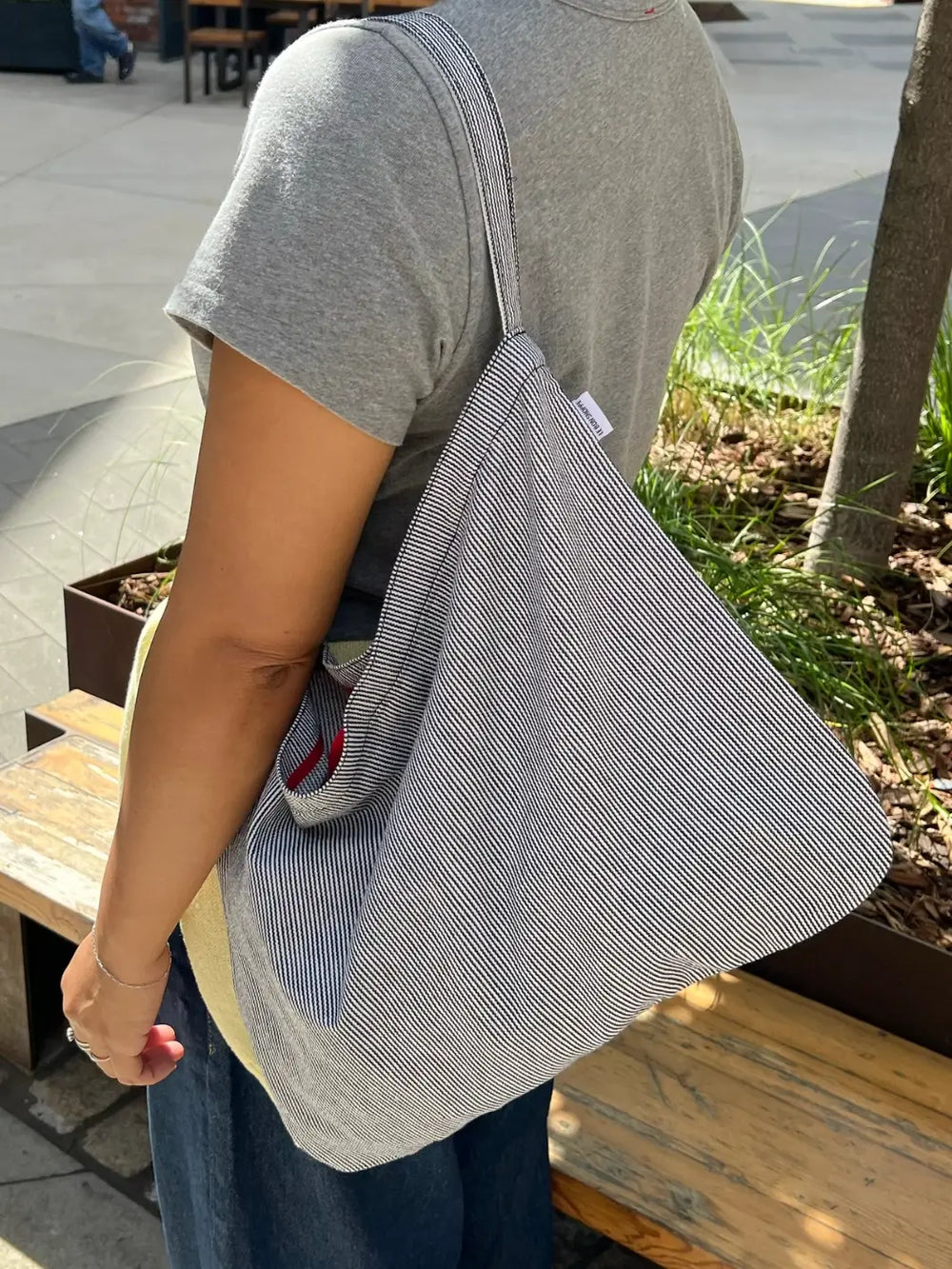 Person holding a Le Bon Shoppe tote bag in 'Blue Stripe' design outdoors | Twentyseven Toronto