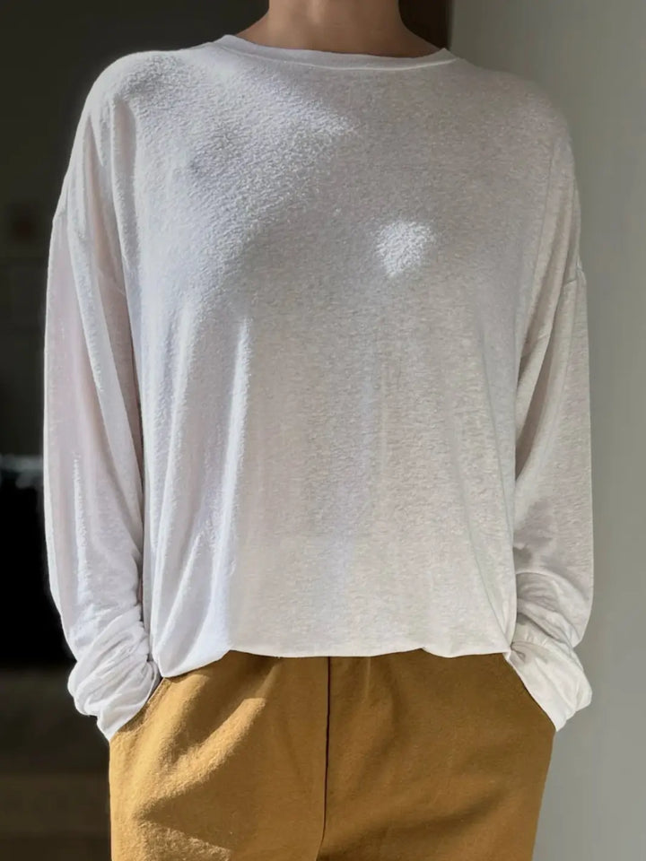 Person wearing a white long-sleeve 'Haze Linen Blend Tee' shirt and mustard pants from Le Bon Shoppe against a neutral background | Twentyseven Toronto