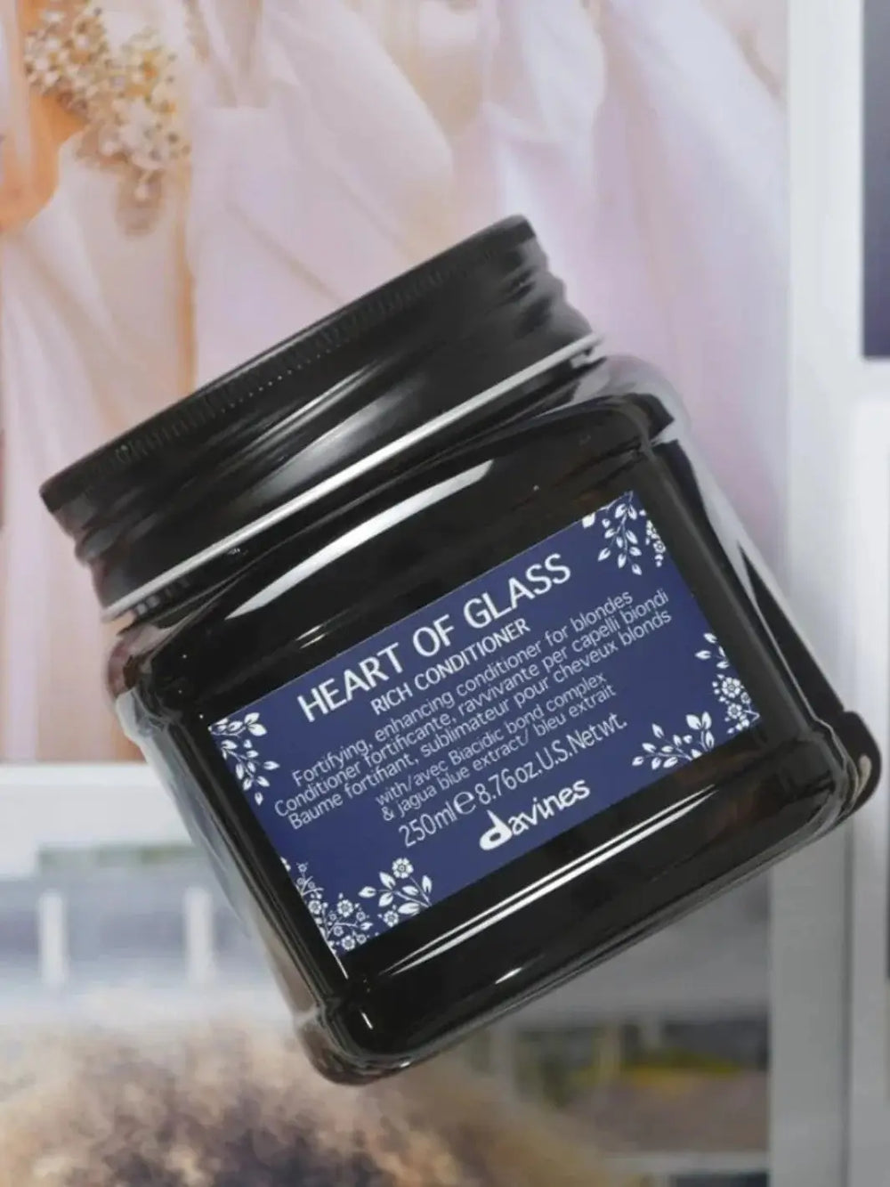 A close-up, angled view shows a dark plastic tub of Davines Heart of Glass Rich Conditioner | Twentyseven Toronto