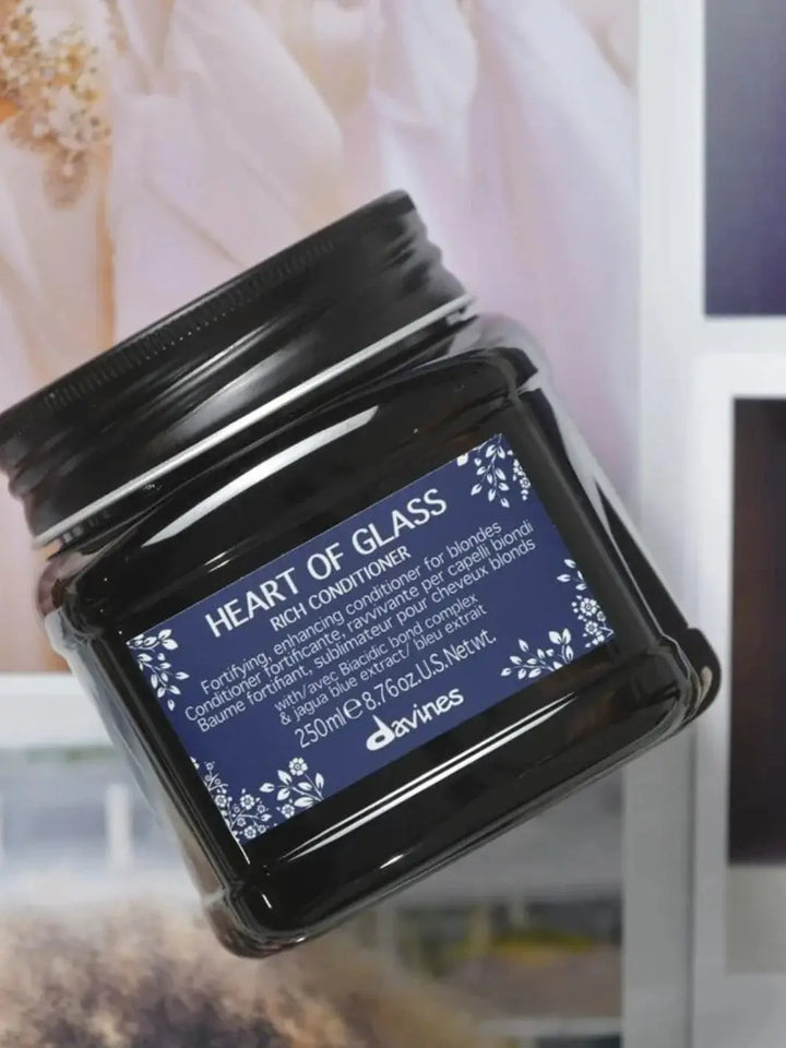 A dark plastic tub of Davines Heart of Glass Rich Conditioner with a deep blue label is shown at a slight angle | Twentyseven Toronto