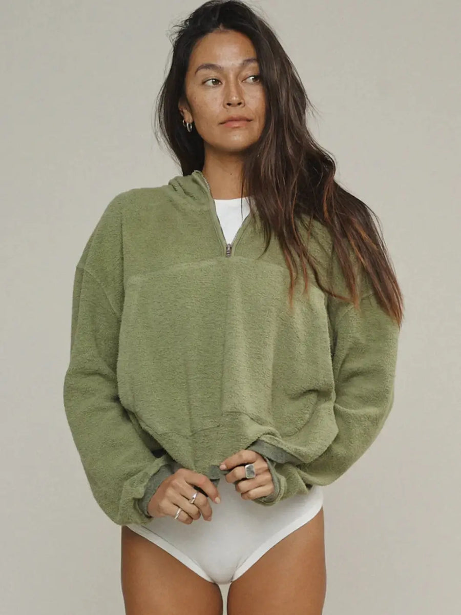 A front view of a model showcasing the half-zip collar and textured fabric of the Jungmaven Heathered Osprey Cropped Sweatshirt - Olive Green | Twentyseven Toronto