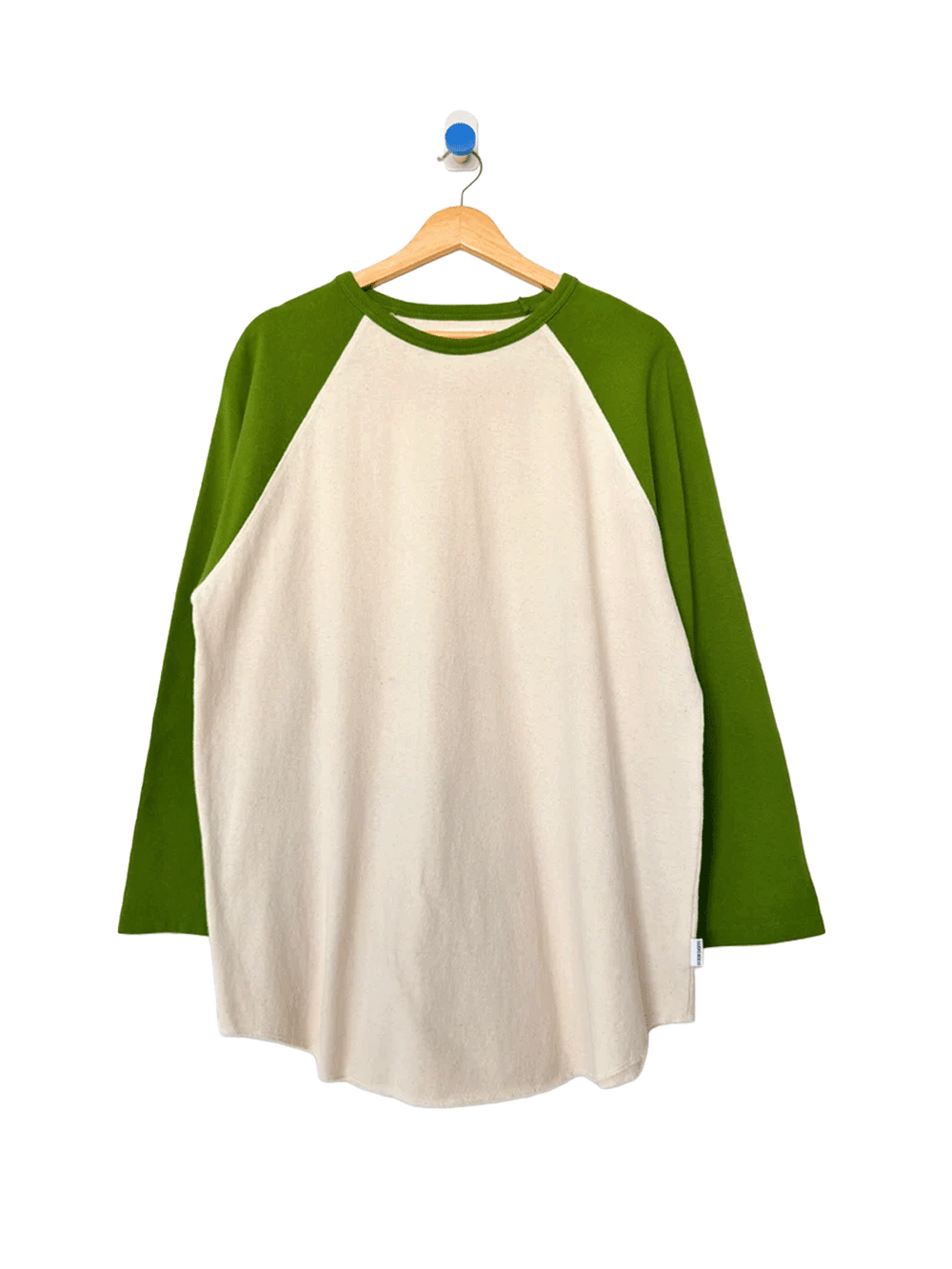 Heavy Cotton Raglan Tee in Naturel/Collard Green displayed on a wooden hanger, featuring a cream body, contrasting green raglan sleeves, crew neckline and relaxed fit | Twentyseven Toronto