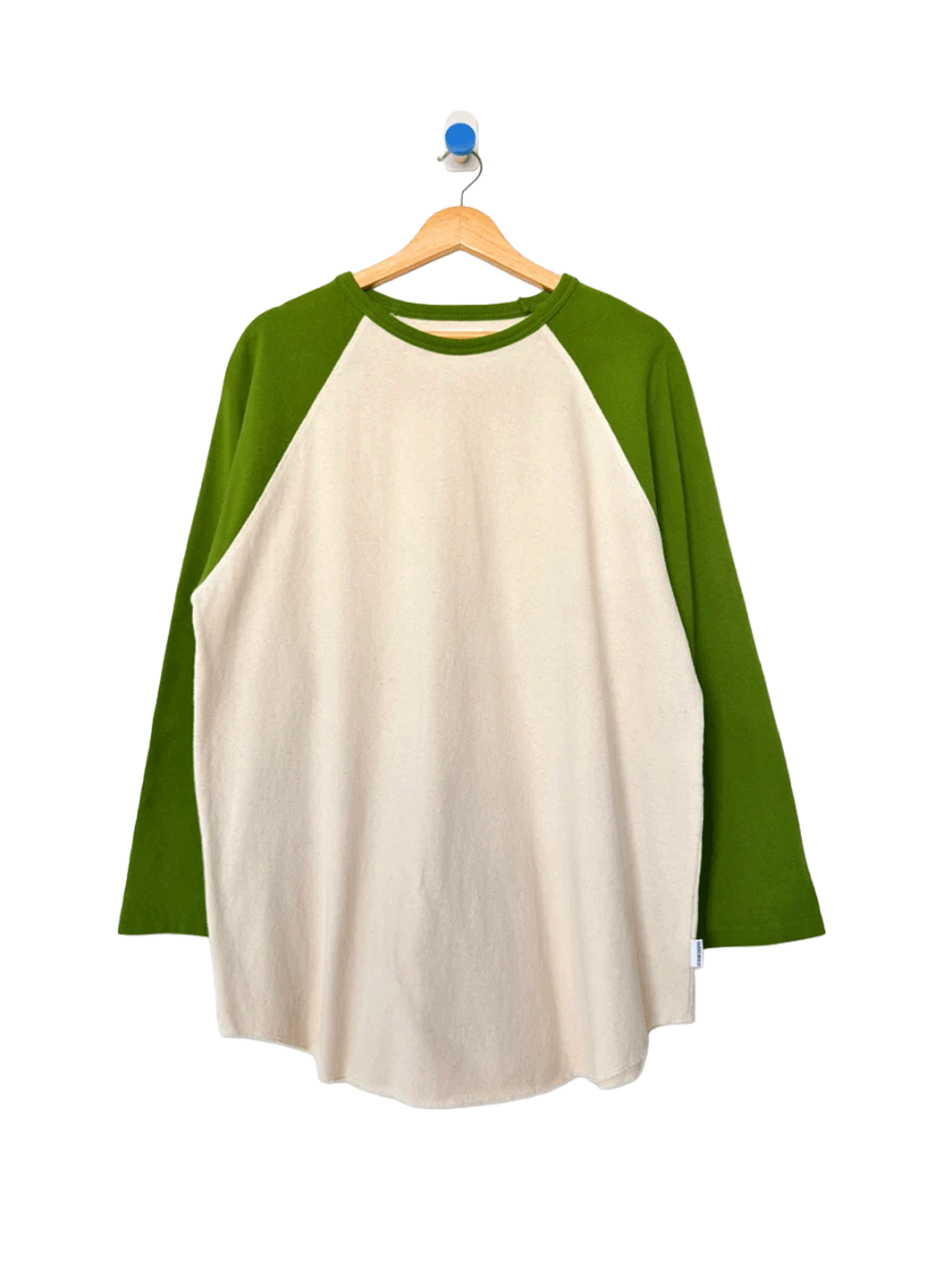 Heavy Cotton Raglan Tee in Naturel/Collard Green displayed on a wooden hanger, featuring a cream body, contrasting green raglan sleeves, crew neckline and relaxed fit | Twentyseven Toronto