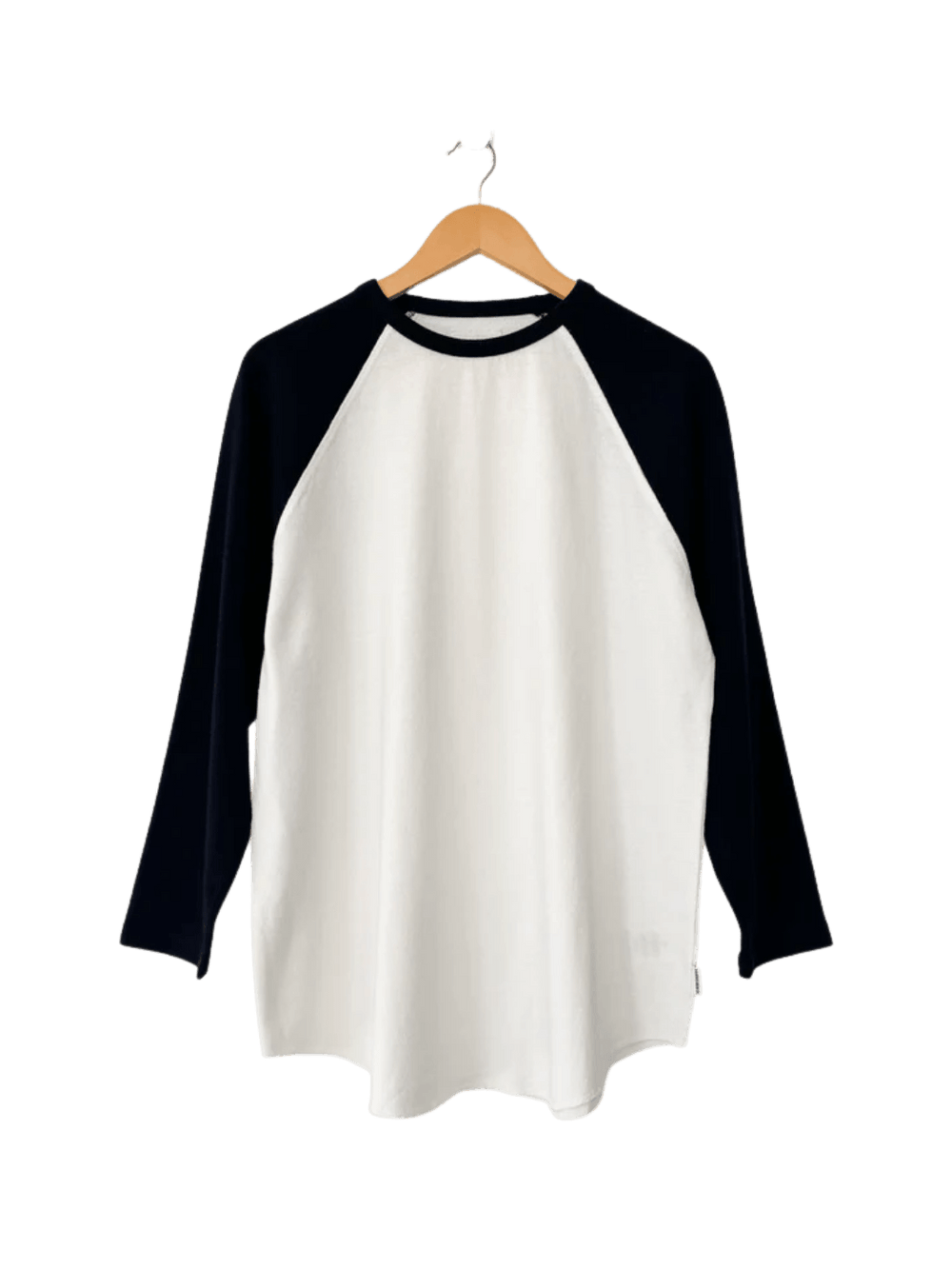 The white and black long-sleeved Le Bon Shoppe Heavy Cotton Raglan Tee in White/Black hangs neatly from a wooden clothing hanger | Twentyseven Toronto