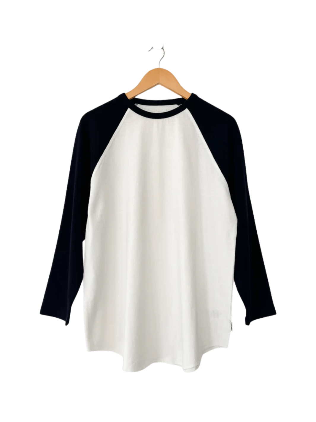 The white and black long-sleeved Le Bon Shoppe Heavy Cotton Raglan Tee in White/Black hangs neatly from a wooden clothing hanger | Twentyseven Toronto