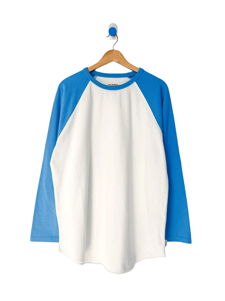 Le Bon Shoppe Heavy Cotton Raglan in white with blue sleeves on a wooden hanger | Twentyseven Toronto