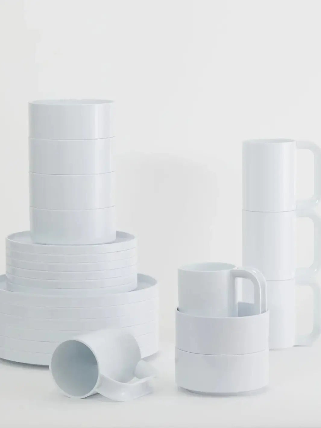 Items from the Heller Max Dinnerware Collection in White - Set of 6, including various stacks of dinner plates, salad plates, bowls, and mugs, are arranged on a white surface | Twentyseven Toronto