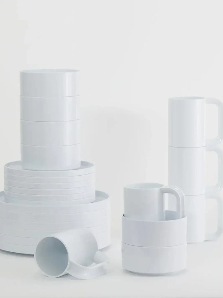 Items from the Heller Max Dinnerware Collection in White - Set of 6, including various stacks of dinner plates, salad plates, bowls, and mugs, are arranged on a white surface | Twentyseven Toronto