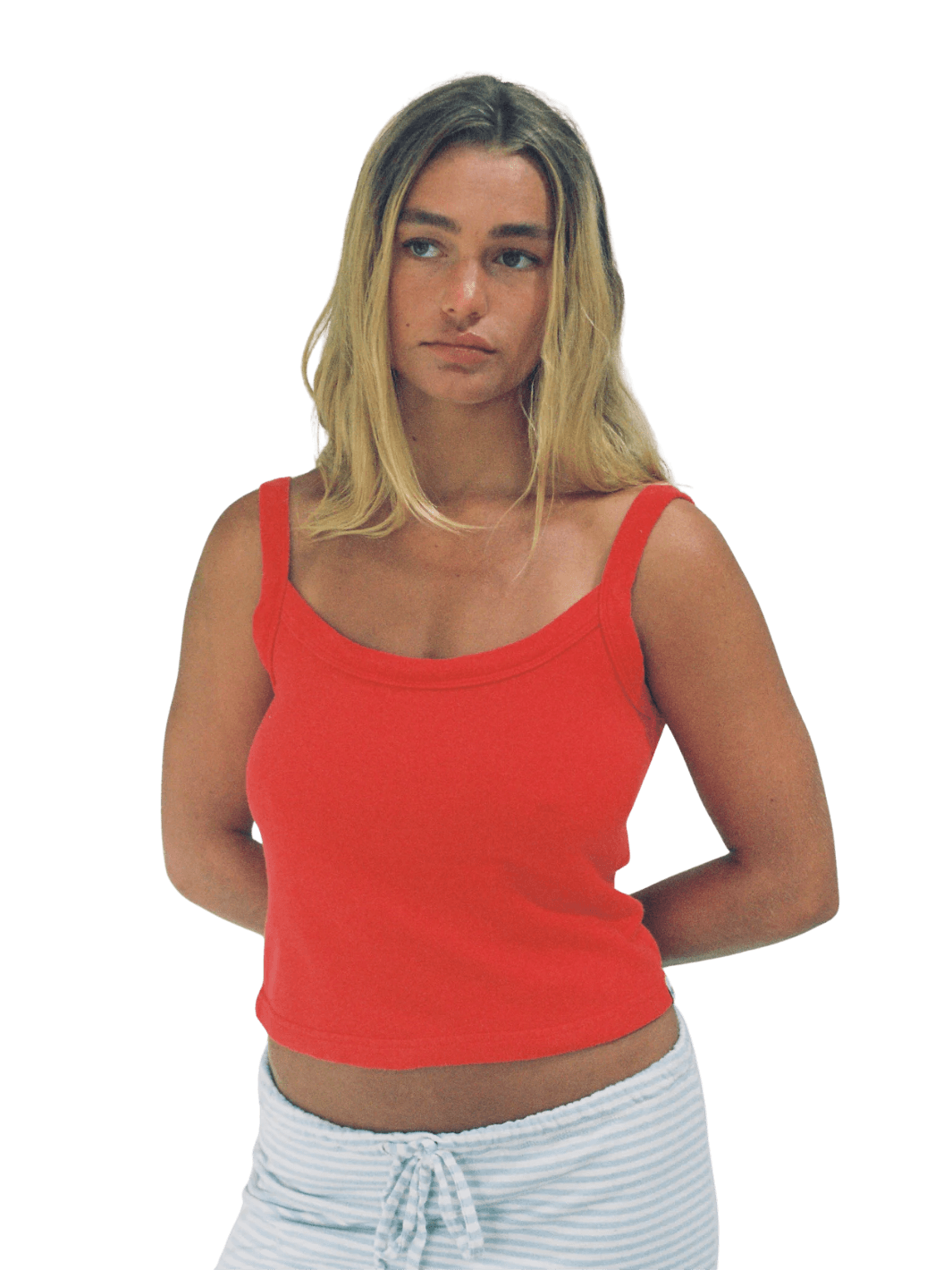 Woman wearing the cropped, vibrant Merge Goods Hemp Breeze Tank Top in Poppy Red and light blue striped shorts with a drawstring | Twentyseven Toronto