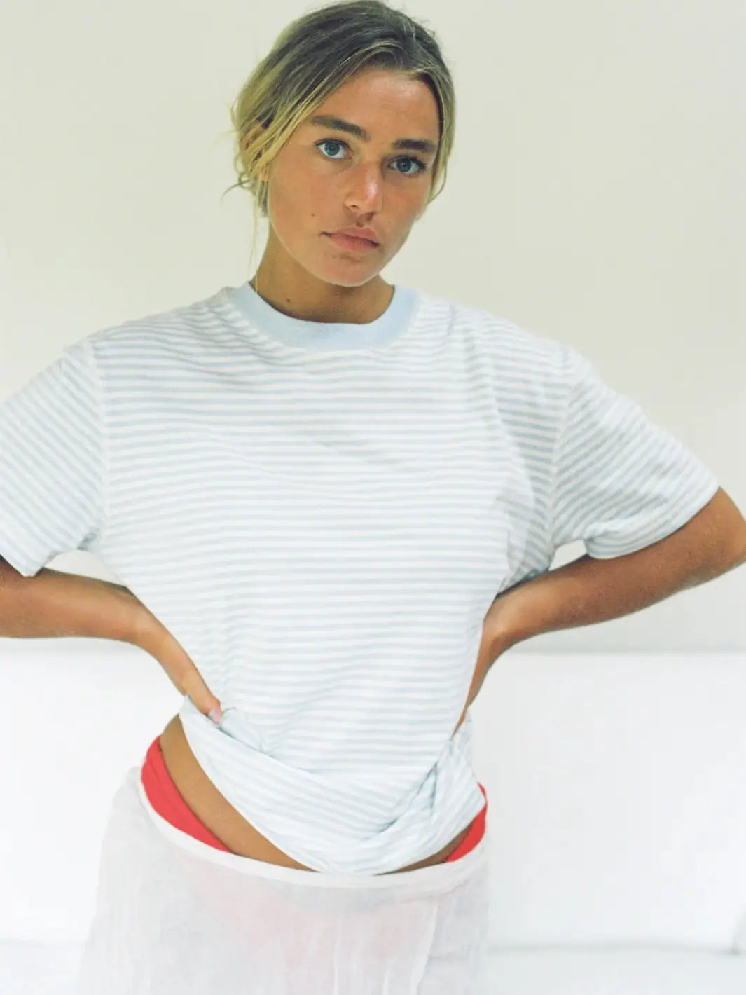 A person stands with hands on hips wearing the casual, crewneck Merge Goods Hemp Rover Tee in Daydream Stripes | Twentyseven Toronto