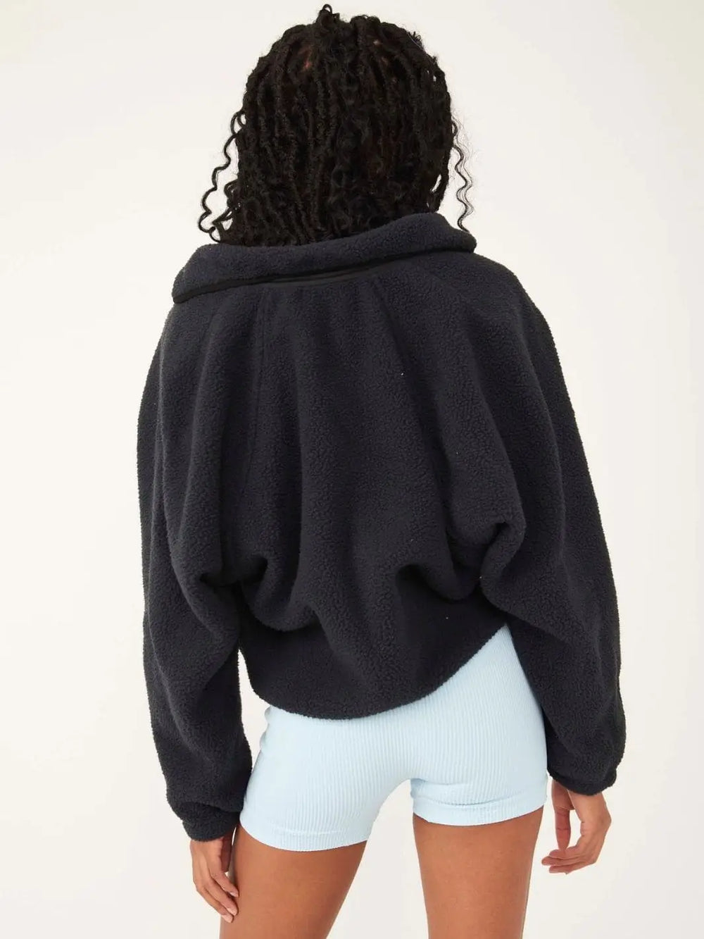 A view from behind captures the slouchy, comfortable fit and clean back design of the Free People Hit The Slopes Fleece Jacket - Black | Twentyseven Toronto