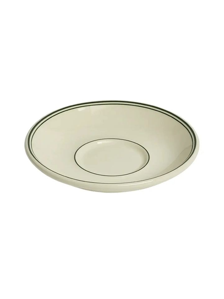 An angled, three-quarter view of an off-white HL Greenband - Saucer (6") from Fishs Eddy showing the inner well and the circular green accent lines | Twentyseven Toronto