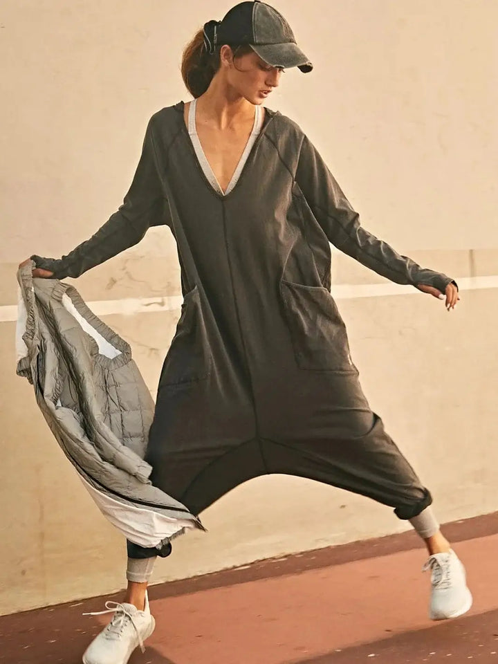 A model wearing the slouchy Free People Hot Shot Long Sleeve Onesie - Black paired with a baseball cap and white sneakers | Twentyseven Toronto