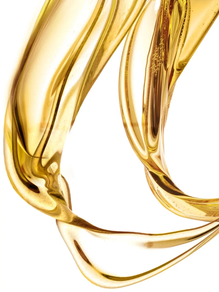 Close-up of 'Huile de Magnolia' gold liquid with a white background | Twentyseven Toronto
