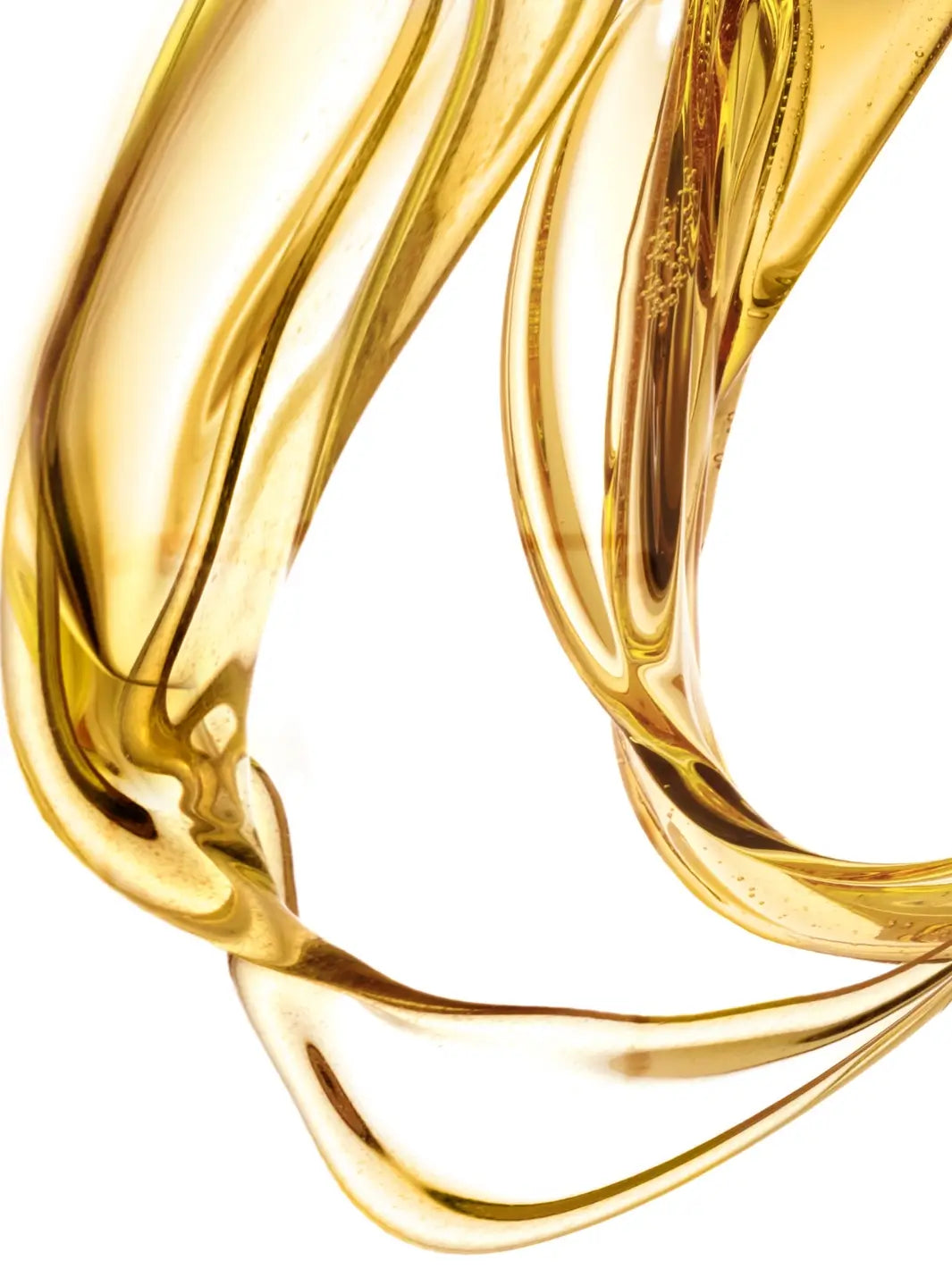 Close-up of 'Huile Secret de Beauté' gold liquid from Leonor Greyl with a white background | Twentyseven Toronto