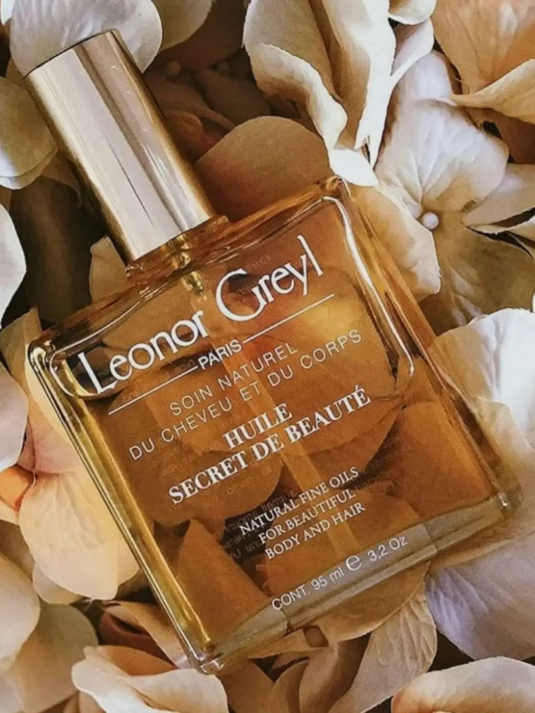 Leonor Greyl 'Huile Secret de Beauté' hair and body oil bottle with floral background | Twentyseven Toronto