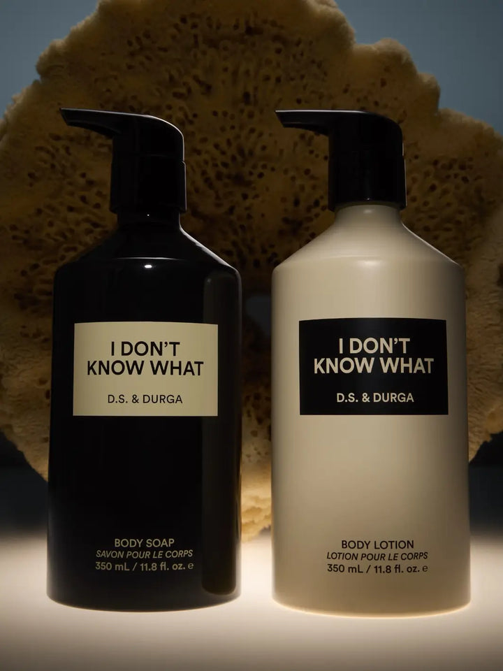 Two bottles of 'I Don't Know What' body soap an body lotion by D.S. & Durga on a dark background | Twentyseven Toronto