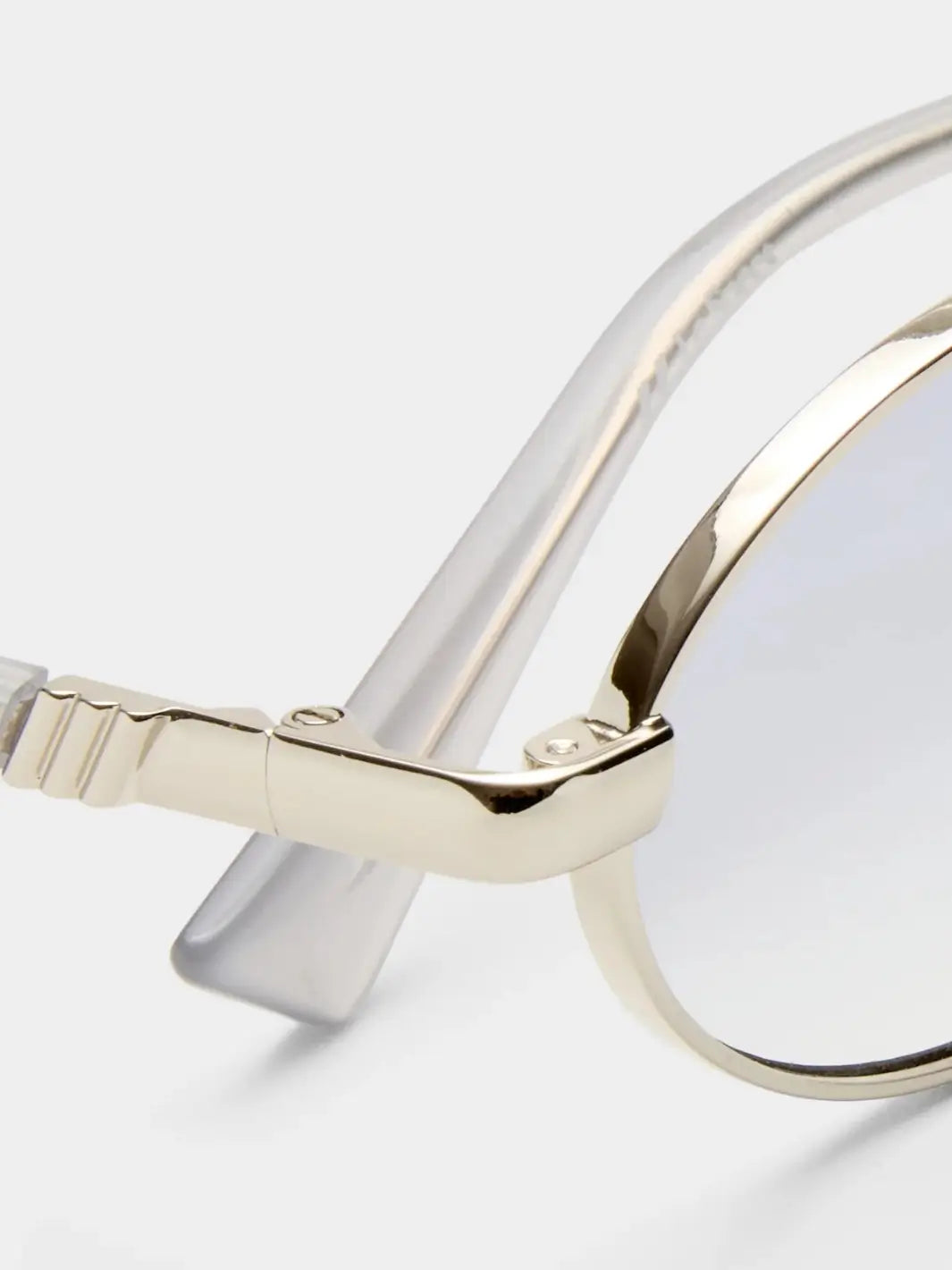 A macro close-up highlighting the sleek metal hinge and clear temple arm attachment of the Le Specs Icicle - Silver Smoke Grad sunglasses | Twentyseven Toronto