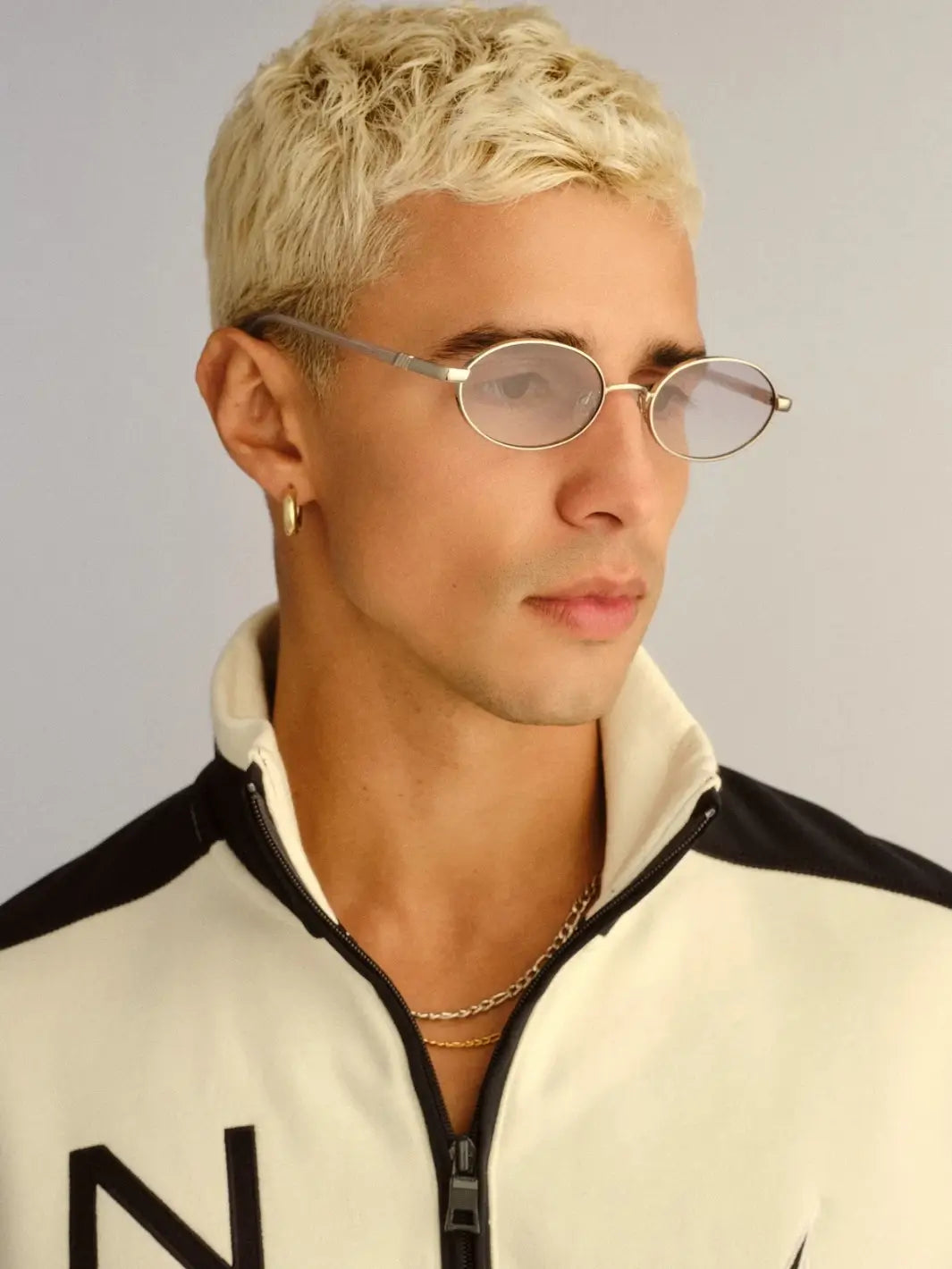 A blonde man looking to the side while wearing the silver-framed Le Specs Icicle - Silver Smoke Grad sunglasses | Twentyseven Toronto