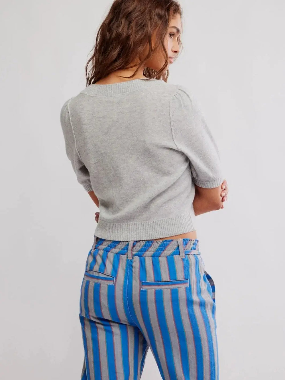 A view from the back highlights the structured crew neckline and ribbed waistband of the form-fitting Free People Isla Solid Cardi - Mineral Grey | Twentyseven Toronto