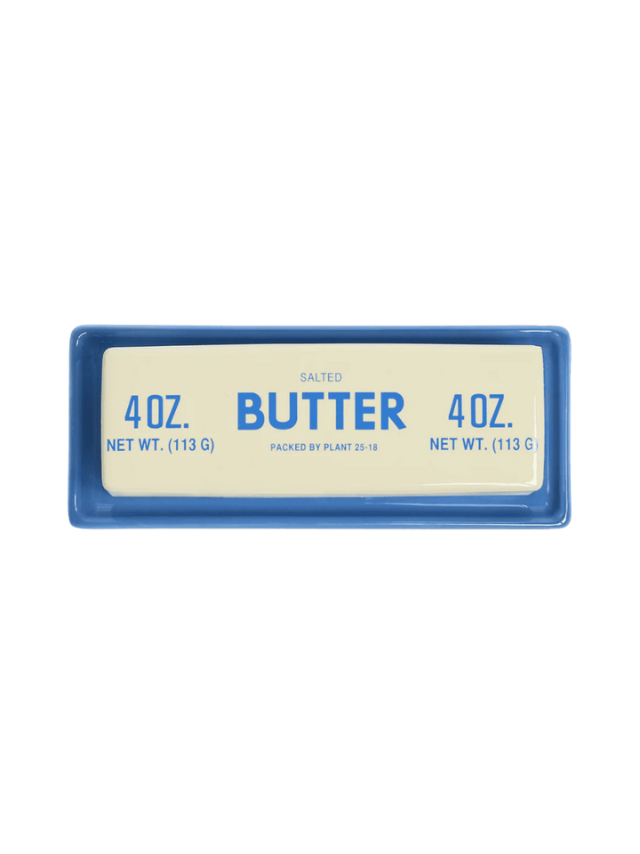 A top-down overhead view of the Item - Butter Stick Butter Dish from Fishs Eddy showcases the vintage-style blue lettering on the cream ceramic lid | Twentyseven Toronto