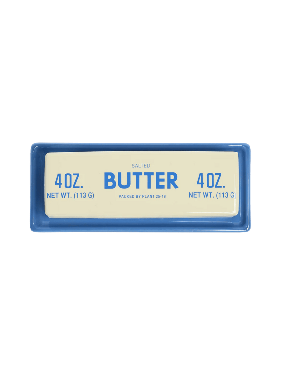 A top-down overhead view of the Item - Butter Stick Butter Dish from Fishs Eddy showcases the vintage-style blue lettering on the cream ceramic lid | Twentyseven Toronto