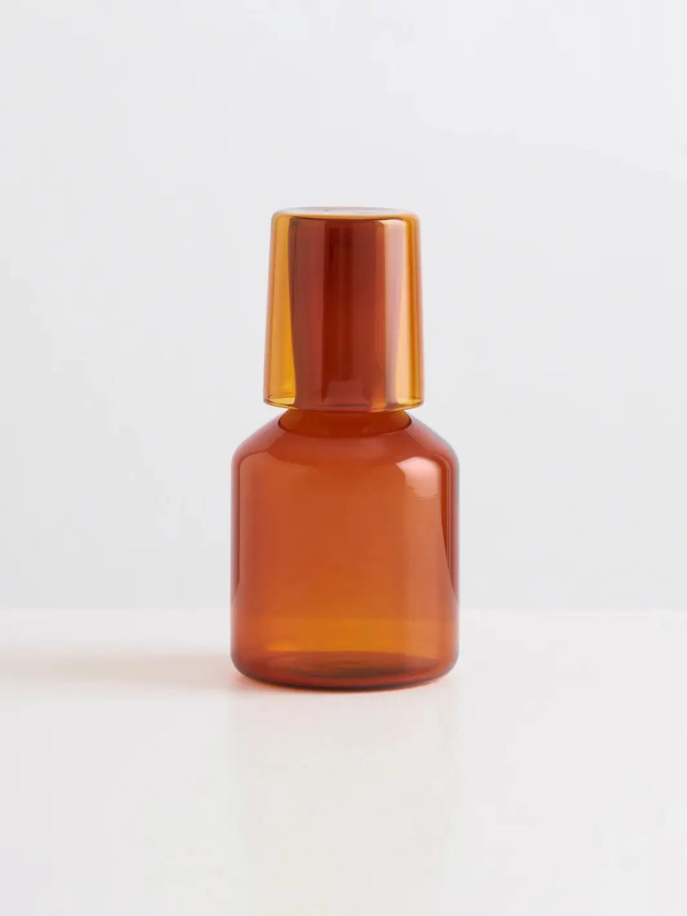 Amber glass 'J'ai Soif' carafe and glass from Maison Balzac on a light gray background | Twentyseven Toronto