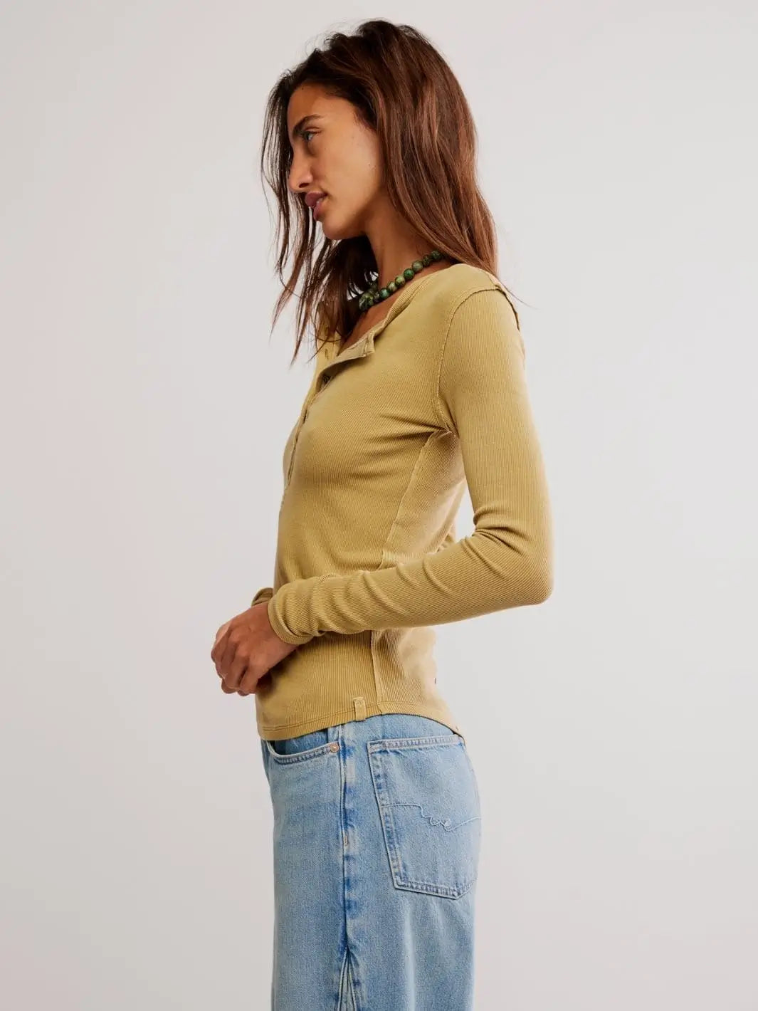 A side profile view highlights the curved hemline, long sleeves, and slim silhouette of the ribbed Free People Jamie Henley - Tobacco | Twentyseven Toronto