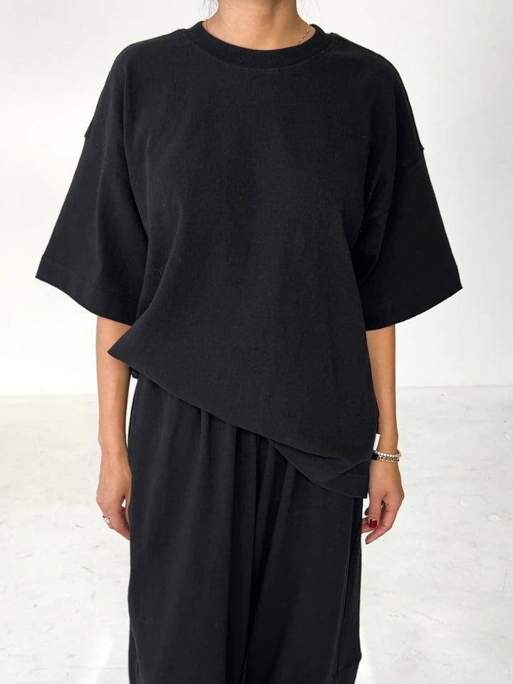 Person wearing black 'Jayden Tee' t-shirt from Le Bon Shoppe with black pants on a white background | Twentyseven Toronto