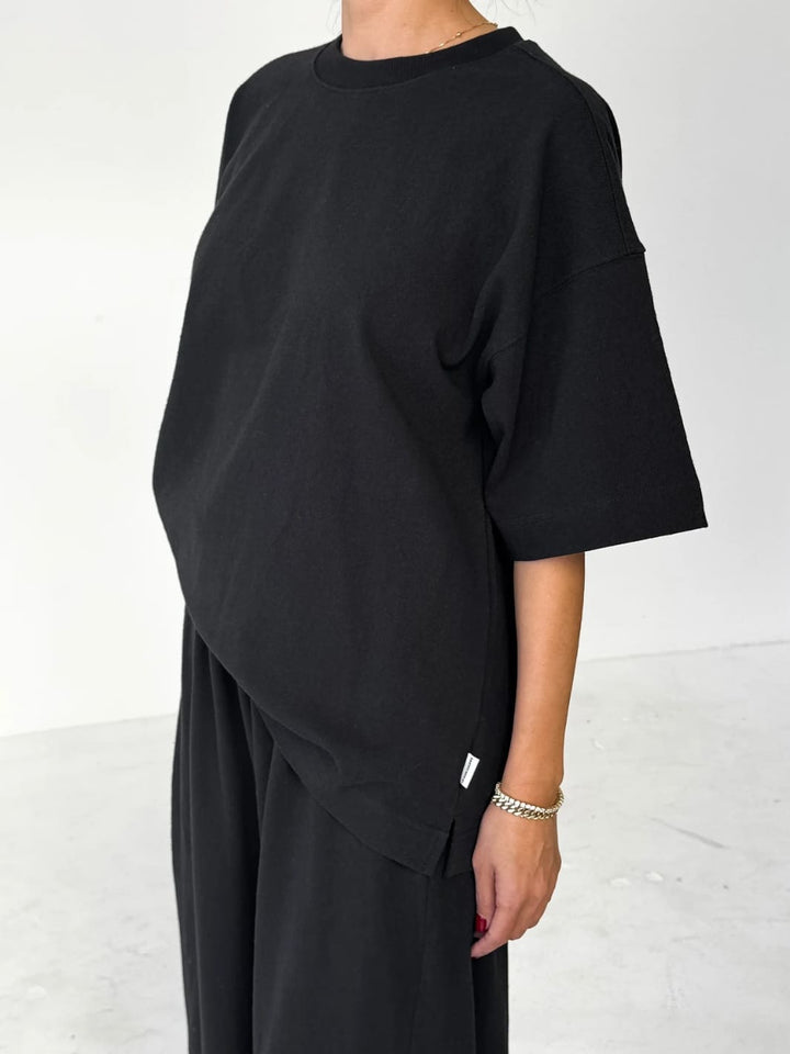 Person wearing black 'Jayden Tee' t-shirt from Le Bon Shoppe with black pants on a white background, 45 degree view | Twentyseven Toronto