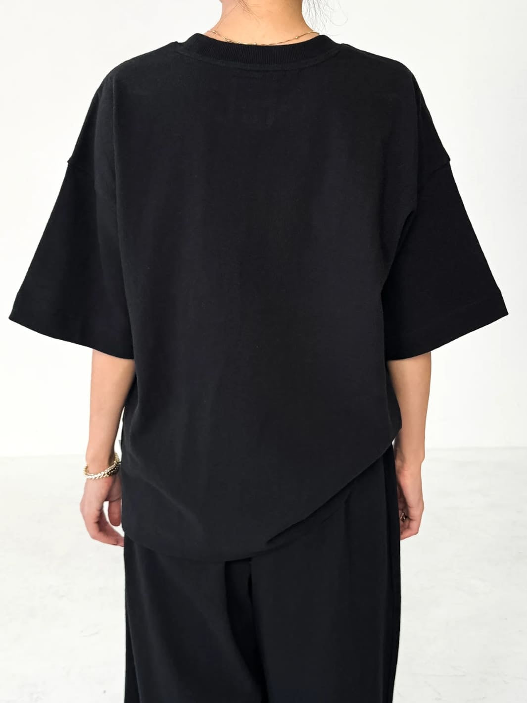 Person wearing black 'Jayden Tee' t-shirt from Le Bon Shoppe with black pants on a white background, back view | Twentyseven Toronto