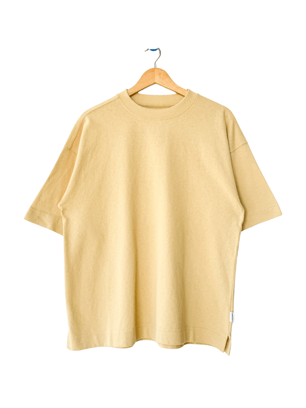 The Le Bon Shoppe Jayden Tee - Butter is displayed flat on a wooden hanger against a transparent background | Twentyseven Toronto