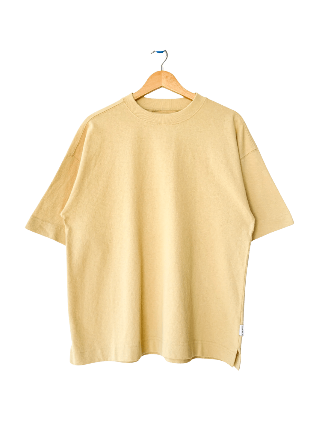 The Le Bon Shoppe Jayden Tee - Butter is displayed flat on a wooden hanger against a transparent background | Twentyseven Toronto