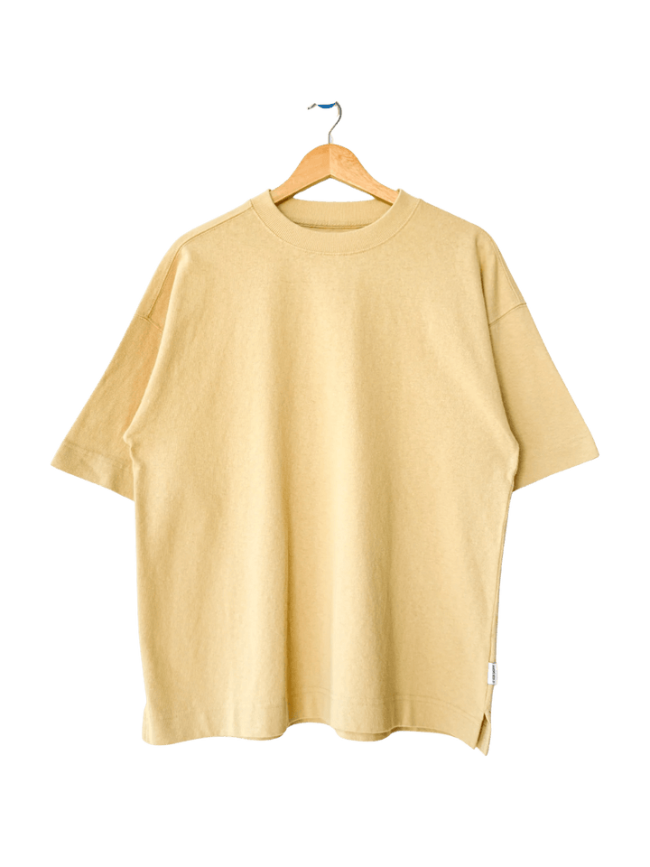 The Le Bon Shoppe Jayden Tee - Butter is displayed flat on a wooden hanger against a transparent background | Twentyseven Toronto