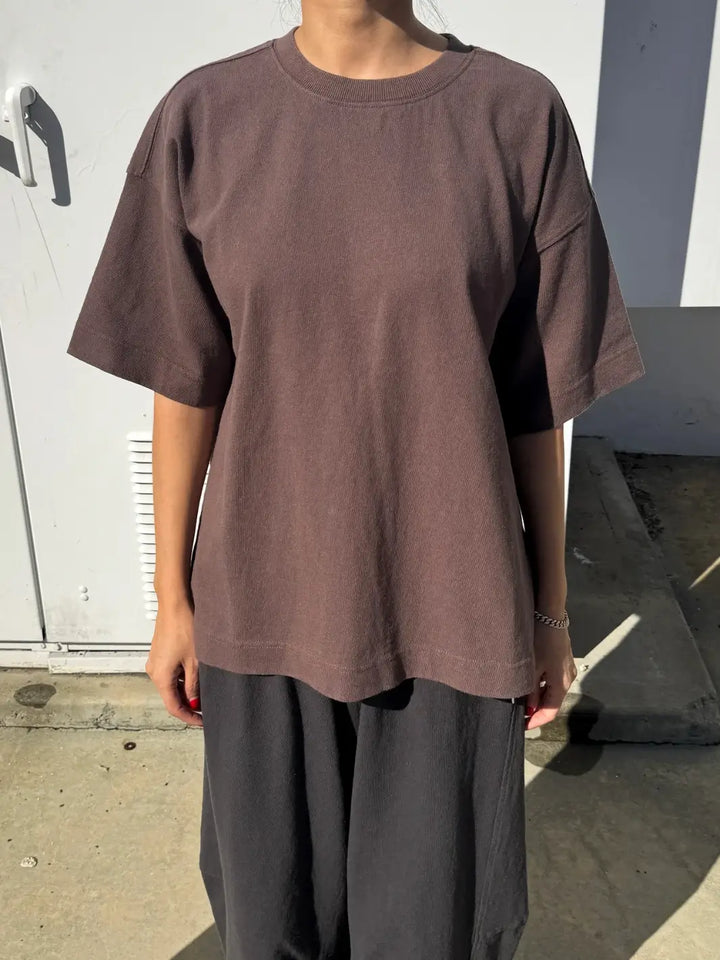 Person wearing dark brown 'Jayden Tee' t-shirt in 'Chocolate' from Le Bon Shoppe with black pants in an outdoor setting | Twentyseven Toronto