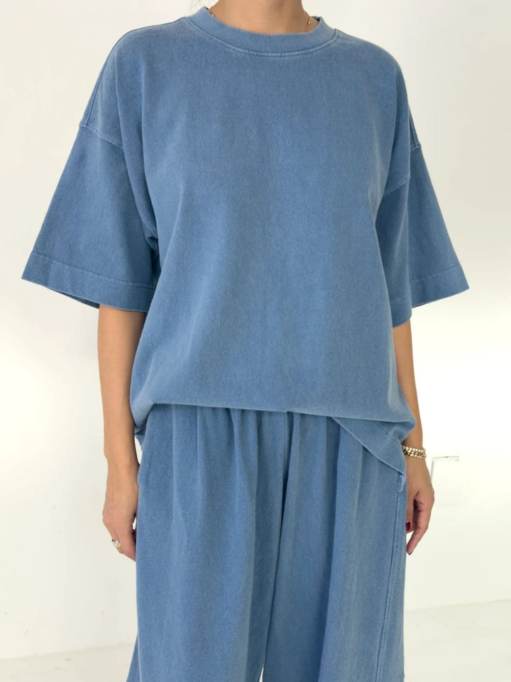 Person wearing blue 'Jayden Tee' in 'Cornflower' t-shirt from Le Bon Shoppe with matching blue pants on a white background | Twentyseven Toronto