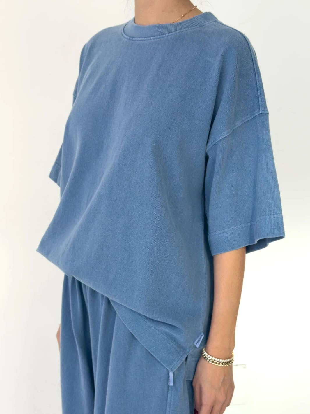 Person wearing blue 'Jayden Tee' t-shirt in 'Cornflower' from Le Bon Shoppe with matching blue pants on a white background, 45 degree view | Twentyseven Toronto