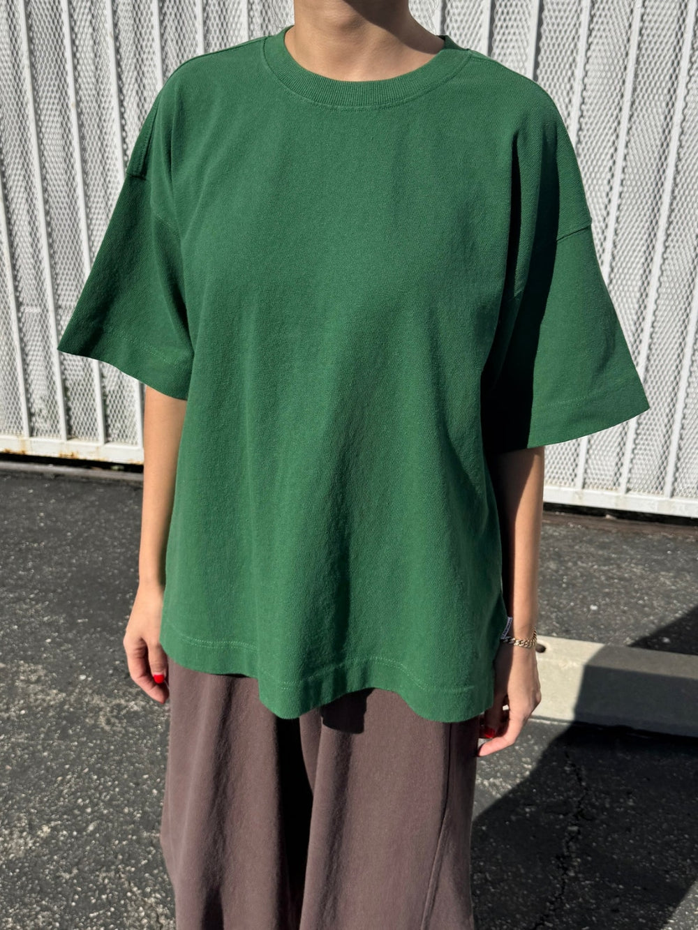 Person wearing dark green 'Jayden Tee' t-shirt in 'Moss Green' from Le Bon Shoppe with brown pants in an outdoor setting | Twentyseven Toronto