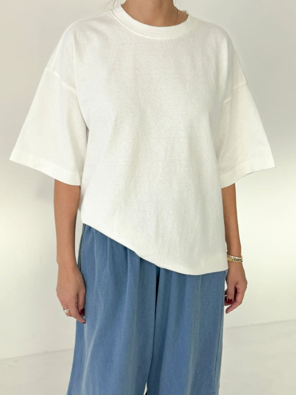 Person wearing white 'Jayden Tee' t-shirt from Le Bon Shoppe with blue pants on a white background | Twentyseven Toronto