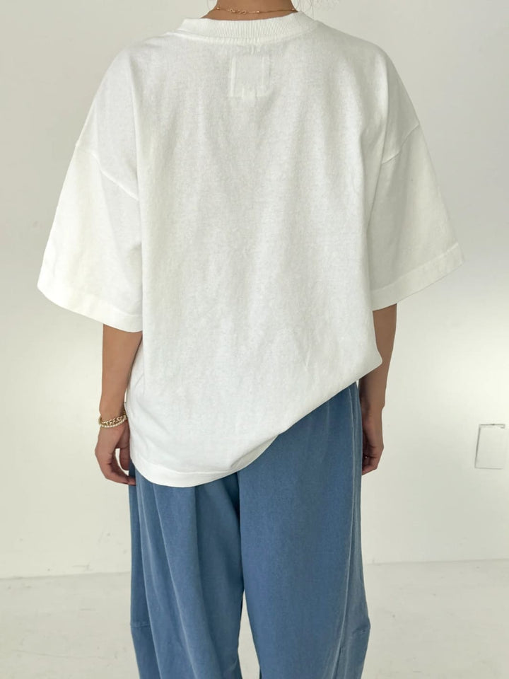 Person wearing white 'Jayden Tee' t-shirt from Le Bon Shoppe with blue pants on a white background, back view | Twentyseven Toronto