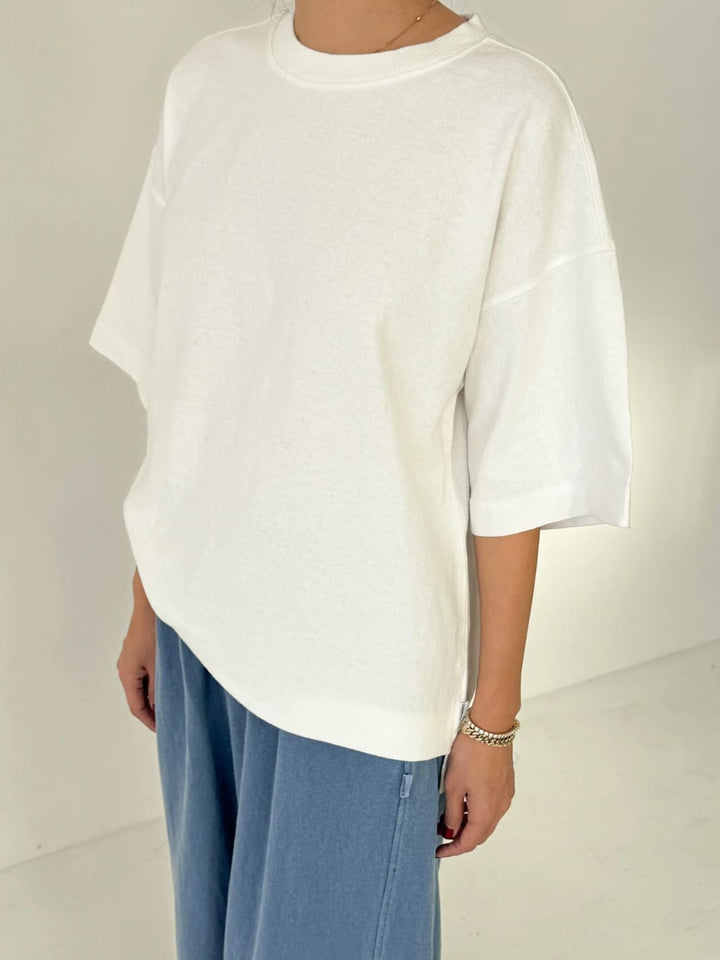 Person wearing white 'Jayden Tee' t-shirt from Le Bon Shoppe with blue pants on a white background, 45 degree view | Twentyseven Toronto