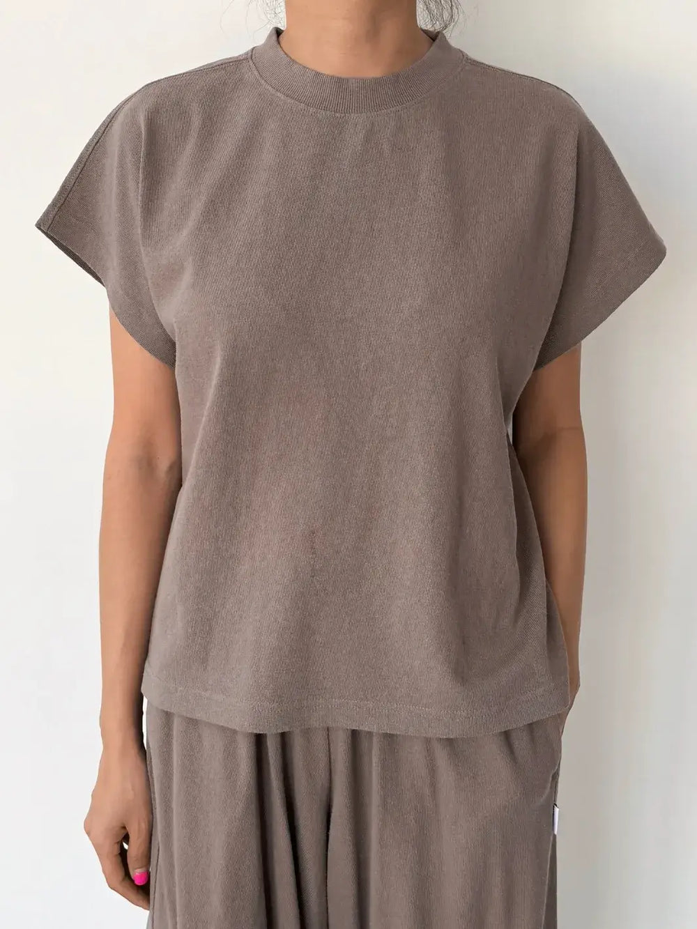 Person wearing a brown sleeveless top, 'Jeanne Tee' in 'Mushroom' from Le Bon Shoppe and matching pants on a white background, front view | Twentyseven Toronto