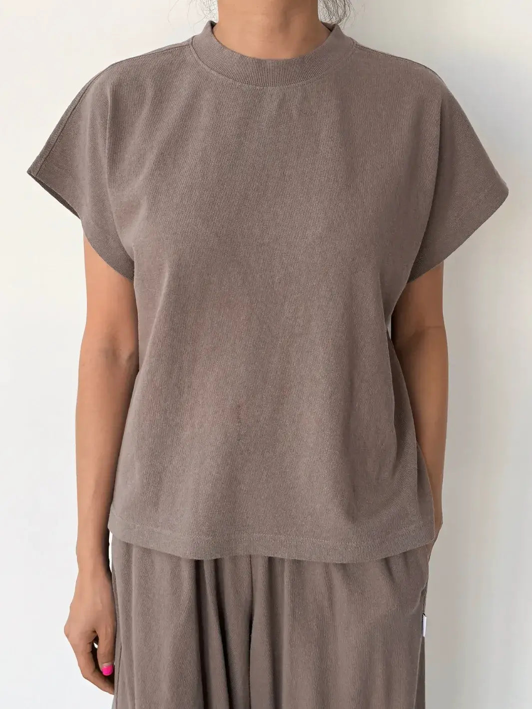 Person wearing a brown sleeveless top, 'Jeanne Tee' in 'Mushroom' from Le Bon Shoppe and matching pants on a white background, front view | Twentyseven Toronto