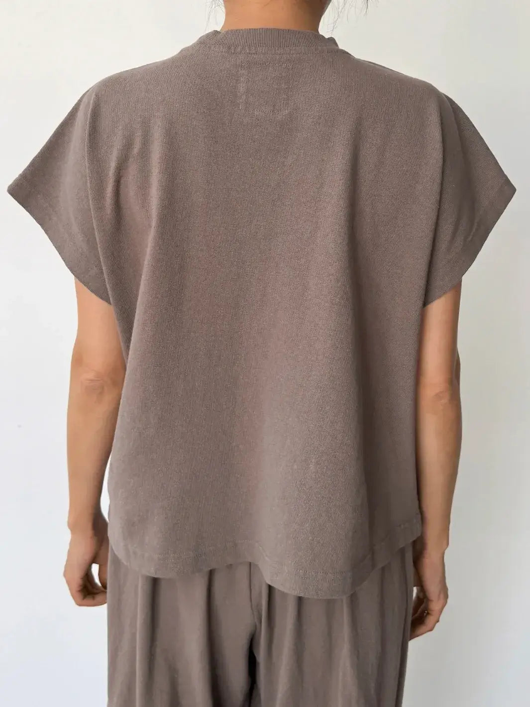 Person wearing a brown sleeveless top, 'Jeanne Tee' in 'Mushroom' from Le Bon Shoppe and matching pants on a white background, back view | Twentyseven Toronto